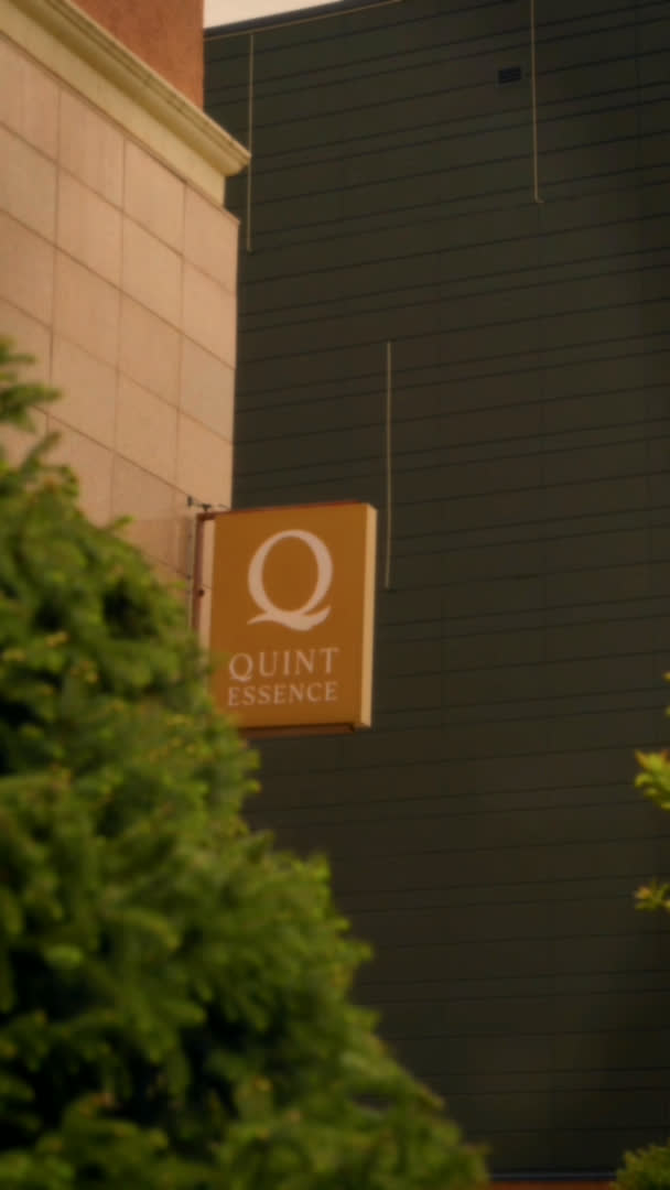 Логотип Quintessence на стеклянной стене клиники